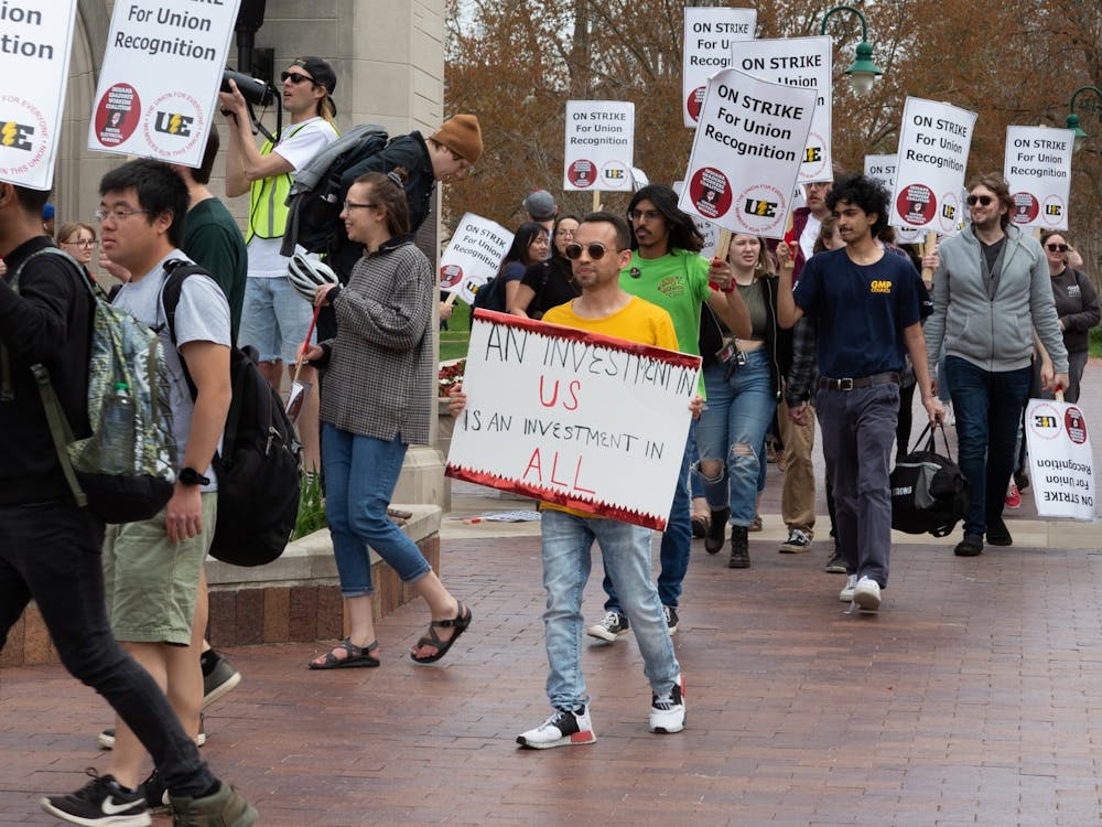 Students from demonstrations around campus march April 15, 2022, through the Sample Gates to join the existing picket line. Cars passed by honking in support of the strike which ingnited cheers and shouts from the protestors.