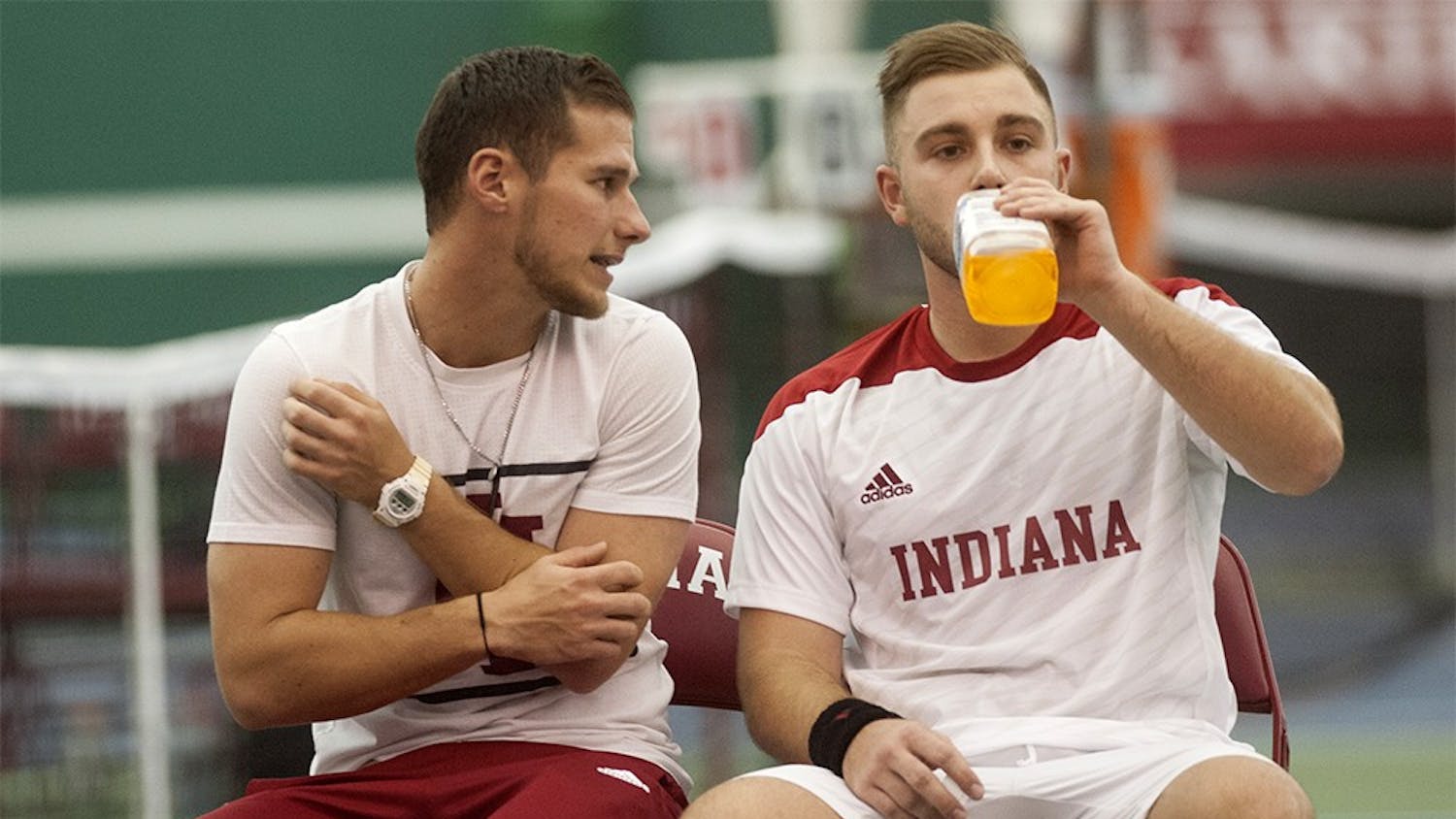 Sven Lalic, left, Volunteer Assistant Coach, speaks to Daniel Bednarczyk during IU's Men's Tennis match against Washington on Feb. 6 at the IU Tennis Center. 