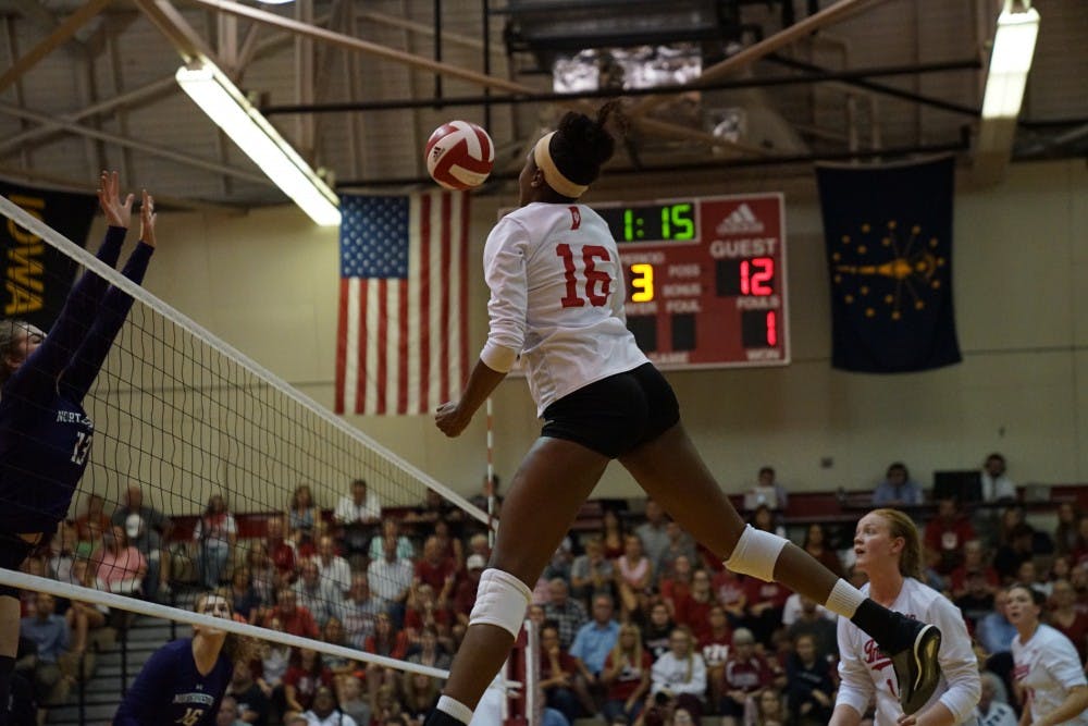 <p>Junior middle blocker Deyshia Lofton spikes the ball against a Northwestern defender Sept. 21 in University Gym. IU is 2-2 in Big Ten Conference play.</p>