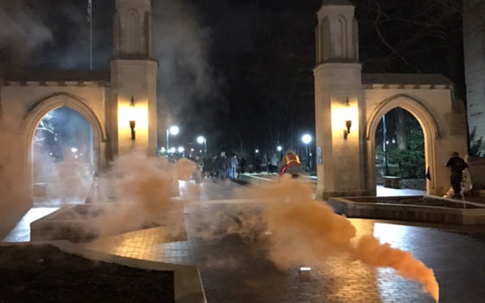 Protesters lit a smoke canister outside Sample Gates on Friday to signifiy the end of their Bloomington protest.