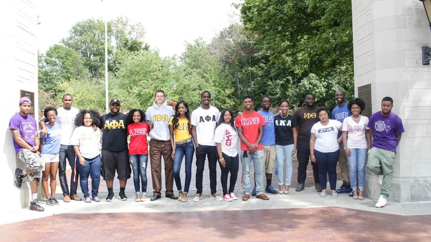 Representatives from the nine historically black fraternities and sororities at IU pose for a photo by Sample Gates. A permanent row of limestone markers will have the names of the United States'&nbsp;nine original black greek chapters &mdash; known as the "Divine Nine" &mdash;&nbsp;arranged in an arc along the sidewalk that leads to the entrance of the Neal-Marshall Black Culture Center building.
