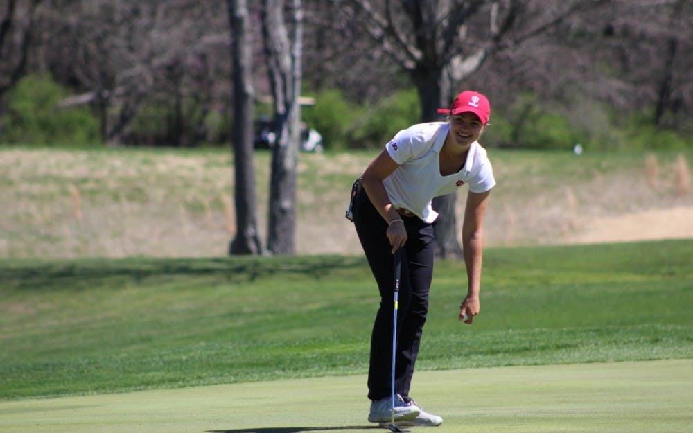 <p>Freshman Emma Fisher picks her ball out of the hole after sinking a putt Saturday, April 8, 2017, during the IU Invitational at the IU Golf Course. The IU women's golf team will take part in the Alexa Stirling Women's Intercollegiate this weekend.</p>