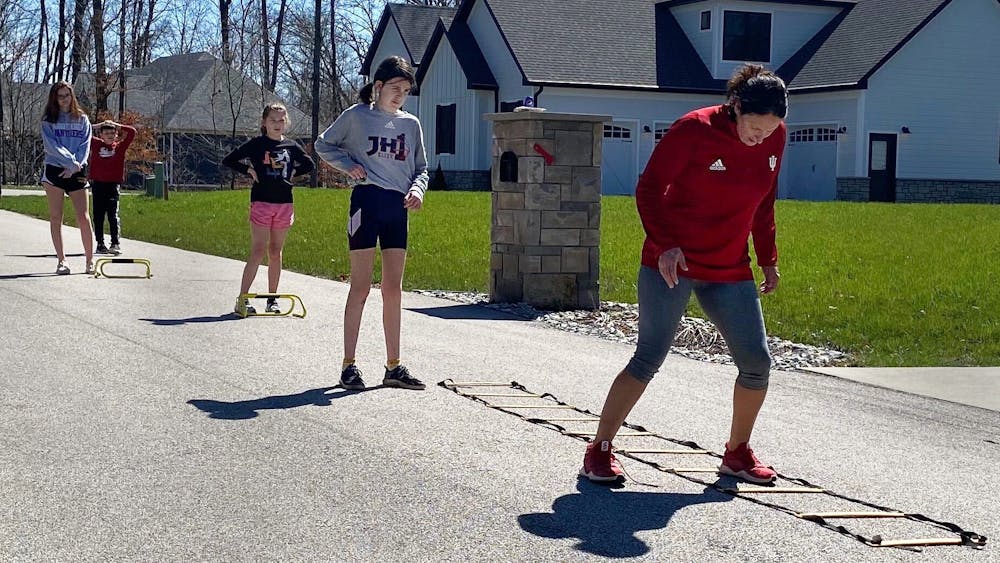 美国国际联盟垒球总教练珊达·斯坦顿(右)在她的社区领导孩子们的锻炼。斯坦顿的课程吸引了她所在社区14个家庭的不同年龄的孩子。