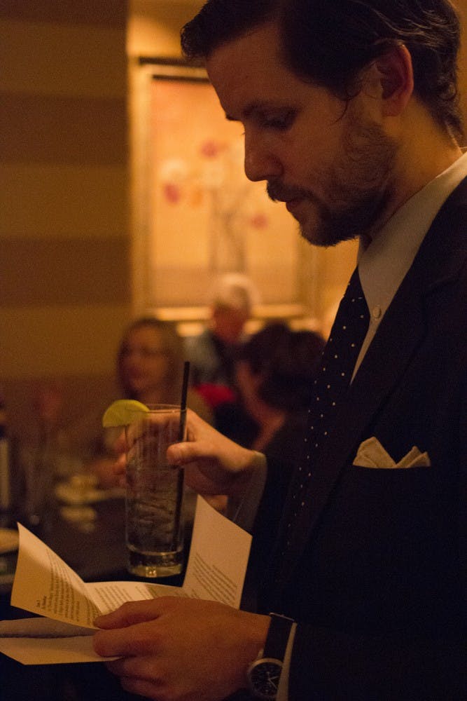Christopher Eichstedt reads his instructions for the Bloomington Murder Mystery club's event at the Scholar's Inn Cafe on Wednesday. 
