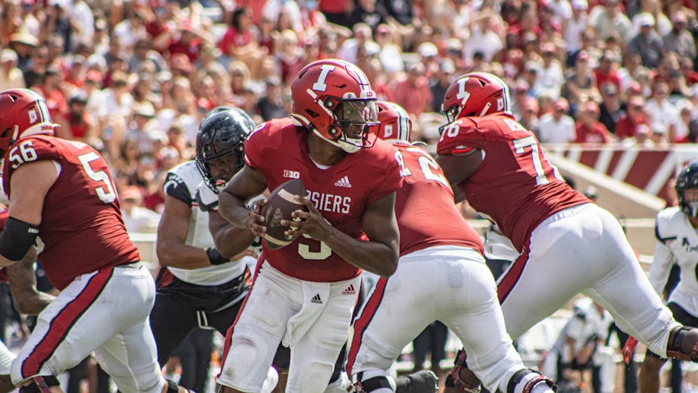 Then-quarterback Michael Penix Jr. rolls out during a play against the University of Cincinnati on Sept. 18, 2021, at Memorial Stadium. The team will unveil its &#x27;90s-themed uniforms on the road against Cincinnati Sept. 24 at Nippert Stadium in Cincinnati, Ohio.