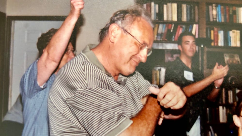 Carl Ziegler dances at his house with Mark Helmsing and other students after a back-to-school student dinner in August 2003. Ziegler, 80, died on April 19.