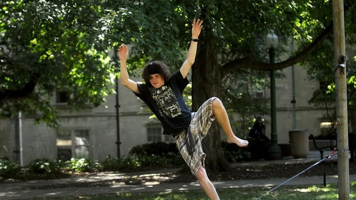 IU freshman Bryce Ledbetter tries to hold his balance on a slackline Thursday afternoon in front of the Collins Living-Learning Center. Slacklining is different from tight rope walking because the nylon webbing is strung at a much lower tension.