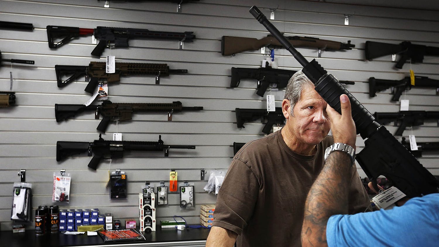 Frank Cobet, gunsmith of the Get Loaded gun store, shows a customer an AR-15 rifle Dec. 8, 2015, in Chino, California. The FBI struggles to complete hundreds of gun background checks each year because of a deadline that requires it to purge them from its computers.