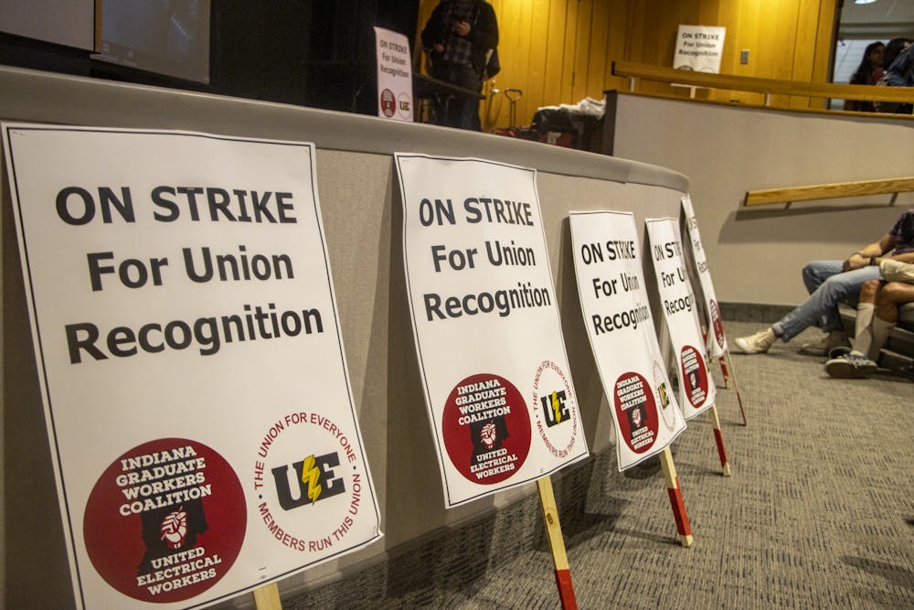 <p>Signs are laid in front the auditorium stage at an in-person vote for the graduate students to go on strike April 10, 2022﻿, at the Monroe County Public Library. The Indiana Graduate Workers Coalition-United Electrical Workers held two Zoom meetings to talk about the strike Wednesday.</p>