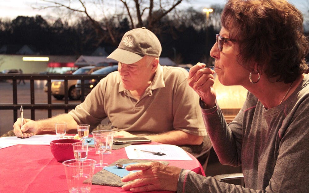 Charles Beckett (left) and Janis DeStefano taste  wine and cheese provided by Kroger on Thursday evening.
