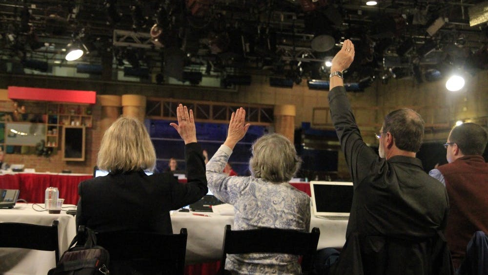 Faculty members raise their hand in agreement with a proposed new lecturer rank during the Bloomington Faculty Council meeting. The March 27 meeting was moved from its original location in Franklin Hall to Studio 6 in the Radio and Television Building.&nbsp;
