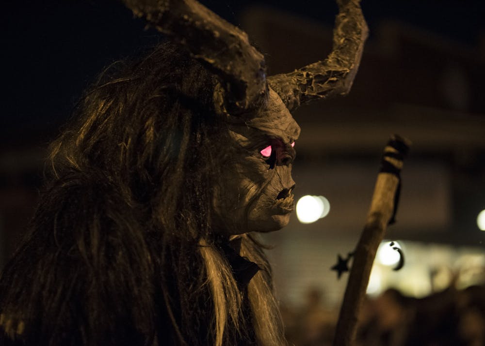 <p>A person dressed as Krampus with glowing red eyes holds a giant stick Dec. 2, 2017, at the Krampus Rampage and Bazaar. Bloomington’s Annual Krampus Rampage and Bazaar, the largest Krampus event in North America will end 5 p.m. Saturday in downtown Bloomington after a decade,<strong> </strong>according to a Bloomington Krampus organization press release. </p><p><br/><br/></p>