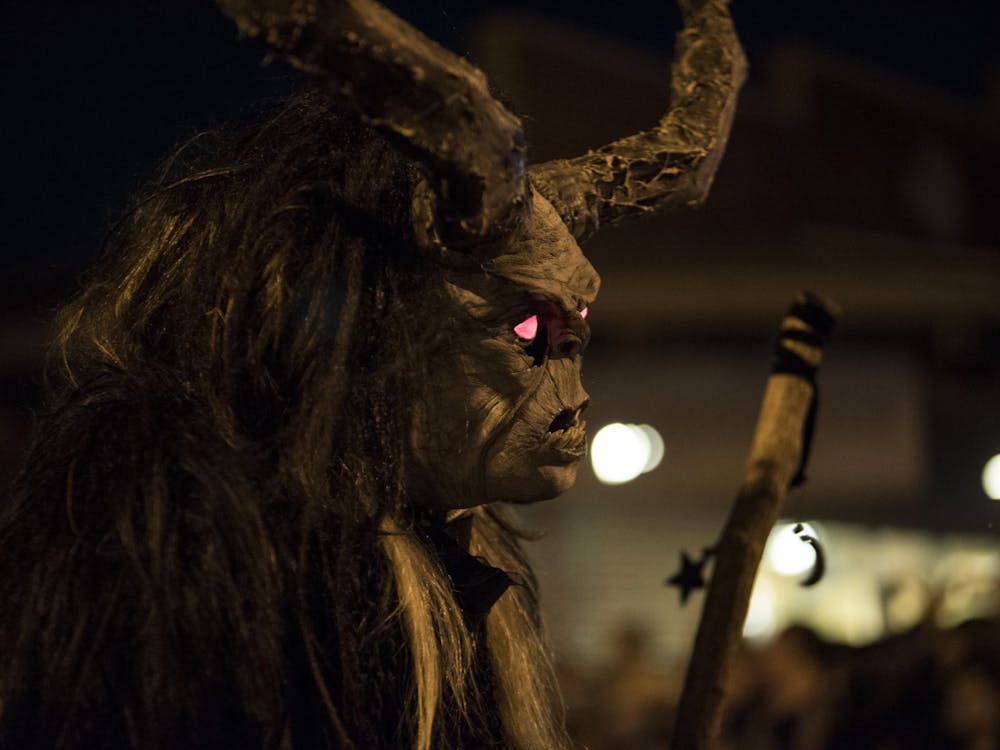 A person dressed as Krampus with glowing red eyes holds a giant stick Dec. 2, 2017, at the Krampus Rampage and Bazaar. Bloomington’s Annual Krampus Rampage and Bazaar, the largest Krampus event in North America will end 5 p.m. Saturday in downtown Bloomington after a decade, according to a Bloomington Krampus organization press release. 