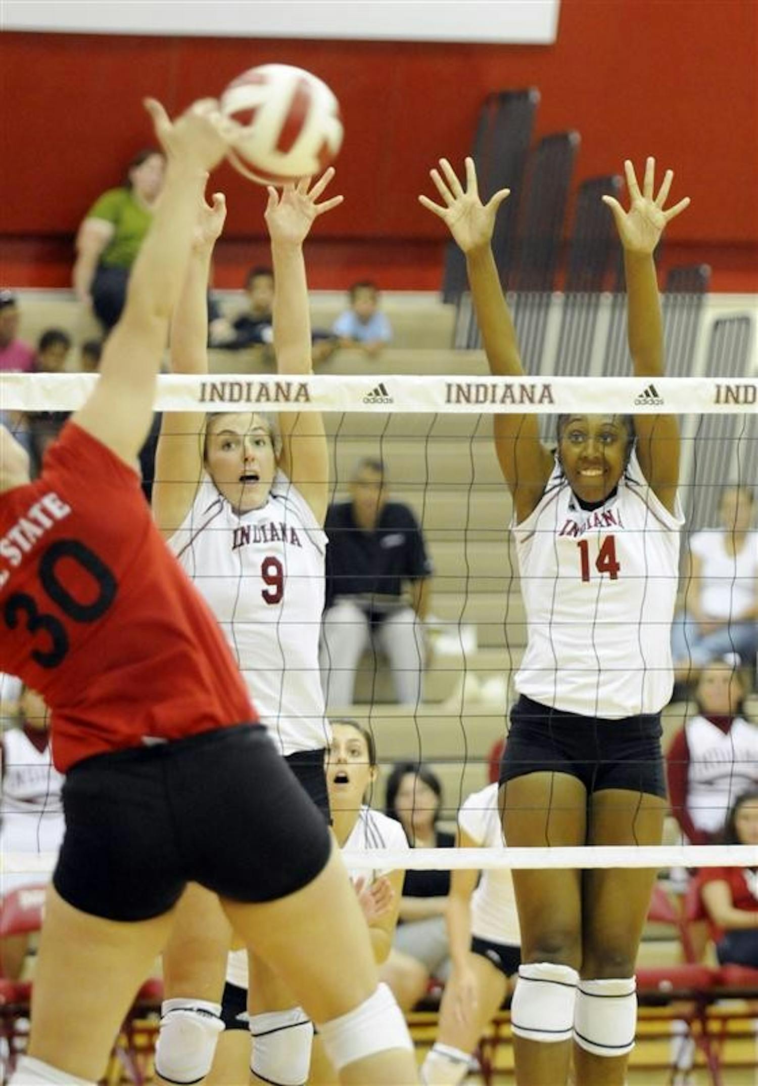 Ball State junior Julia Breivogel spikes on IU's Taylor Wittmer, No. 9, and Lexie Woodson during the TIS Bookstore Invitational on Sept. 19 at University Gym. IU swept Ball State 3-0.