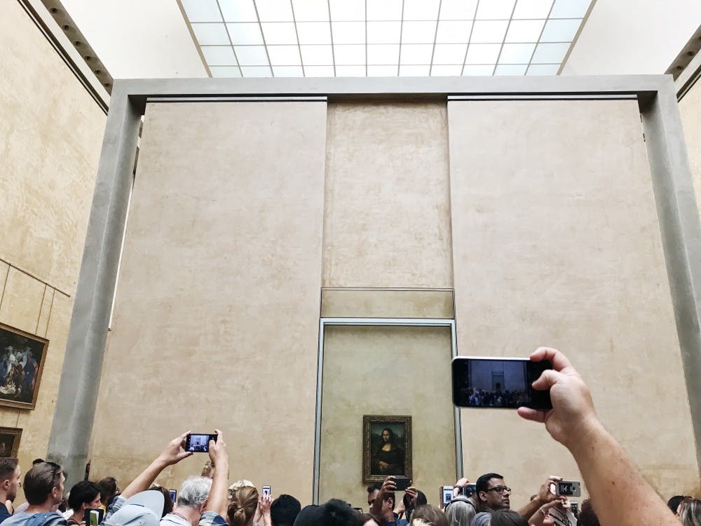 <p>Tourists take photos of "Mona Lisa" at the Louvre Museum in Paris.</p>
