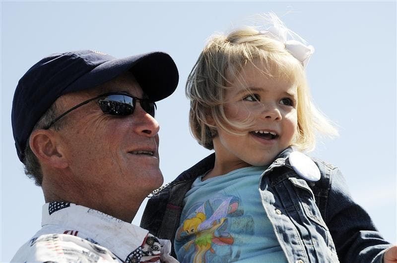 Gov. Mitch Daniels holds Zoe Knotts, 3, as her mother takes a photo during a stop on a charity motorcycle ride on Friday at a Harley-Davidson dealership in Bloomington. Daniels joined members of the American Bikers Aimed Towards Education on the ride, which attracted about 300 motorcycles and benefited the National Guard Relief Fund.