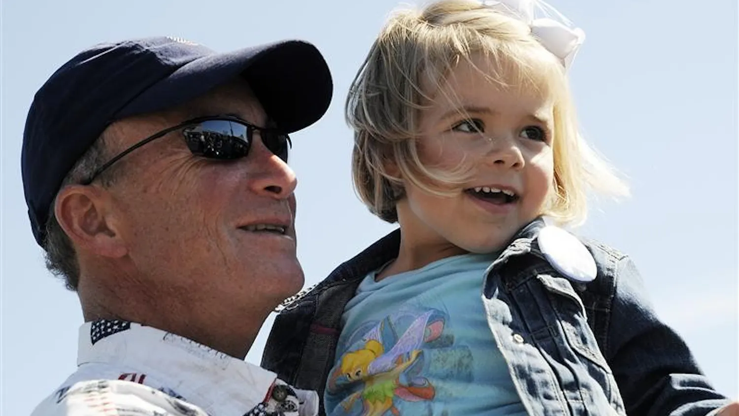 Gov. Mitch Daniels holds Zoe Knotts, 3, as her mother takes a photo during a stop on a charity motorcycle ride on Friday at a Harley-Davidson dealership in Bloomington. Daniels joined members of the American Bikers Aimed Towards Education on the ride, which attracted about 300 motorcycles and benefited the National Guard Relief Fund.