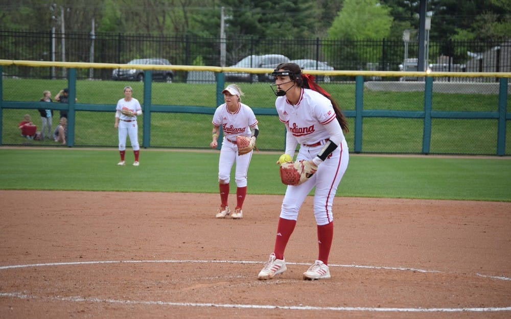 Sophomore pitcher Emily Kirk focuses on the strike zone while shortstop Rachel O'Malley prepares for a play in the background.&nbsp;The Hoosiers defeated the Terrapins in all three games in Bloomington.
