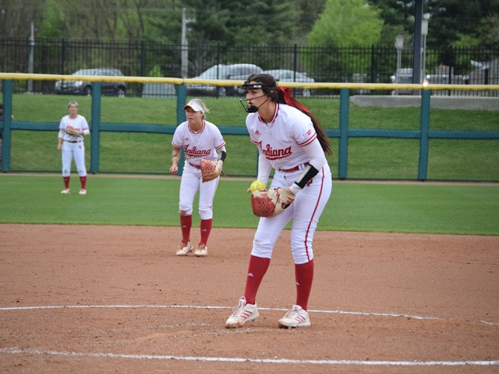Sophomore pitcher Emily Kirk focuses on the strike zone while shortstop Rachel O'Malley prepares for a play in the background.&nbsp;The Hoosiers defeated the Terrapins in all three games in Bloomington.