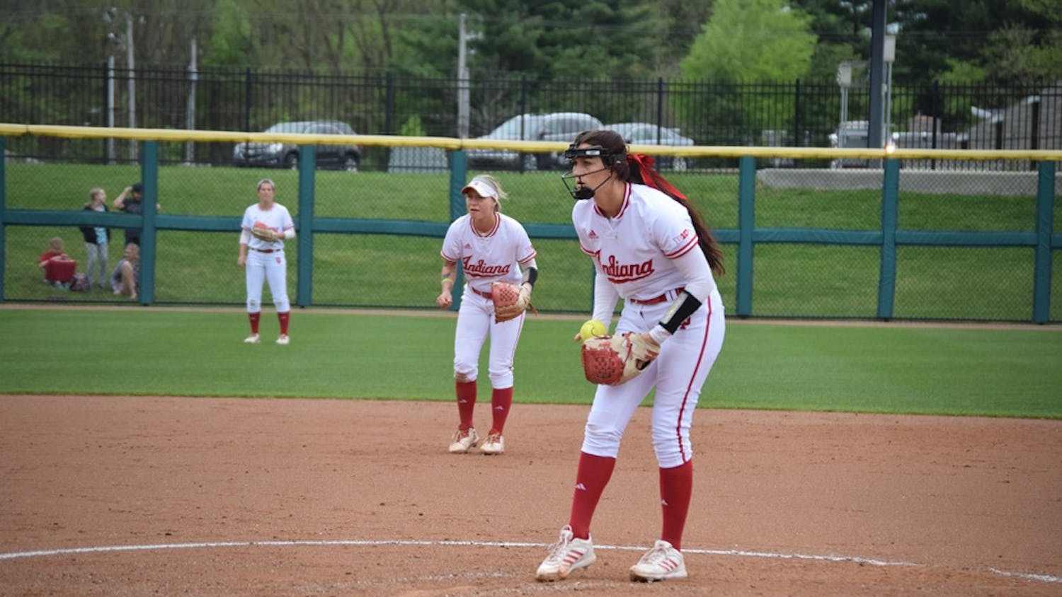 Sophomore pitcher Emily Kirk focuses on the strike zone while shortstop Rachel O'Malley prepares for a play in the background.&nbsp;The Hoosiers defeated the Terrapins in all three games in Bloomington.
