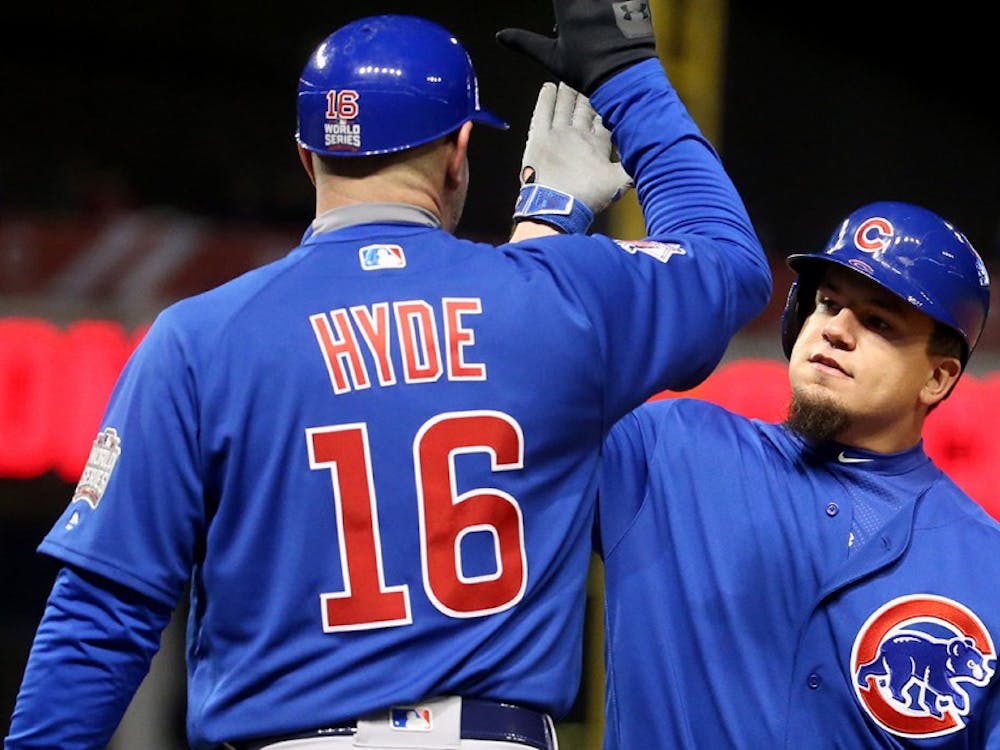 Chicago Cubs designated hitter Kyle Schwarber high-fives first base coach Brandon Hyde (16) after an RBI single in the fifth inning during Game 2 of the World Series on Wednesday, Oct. 26.