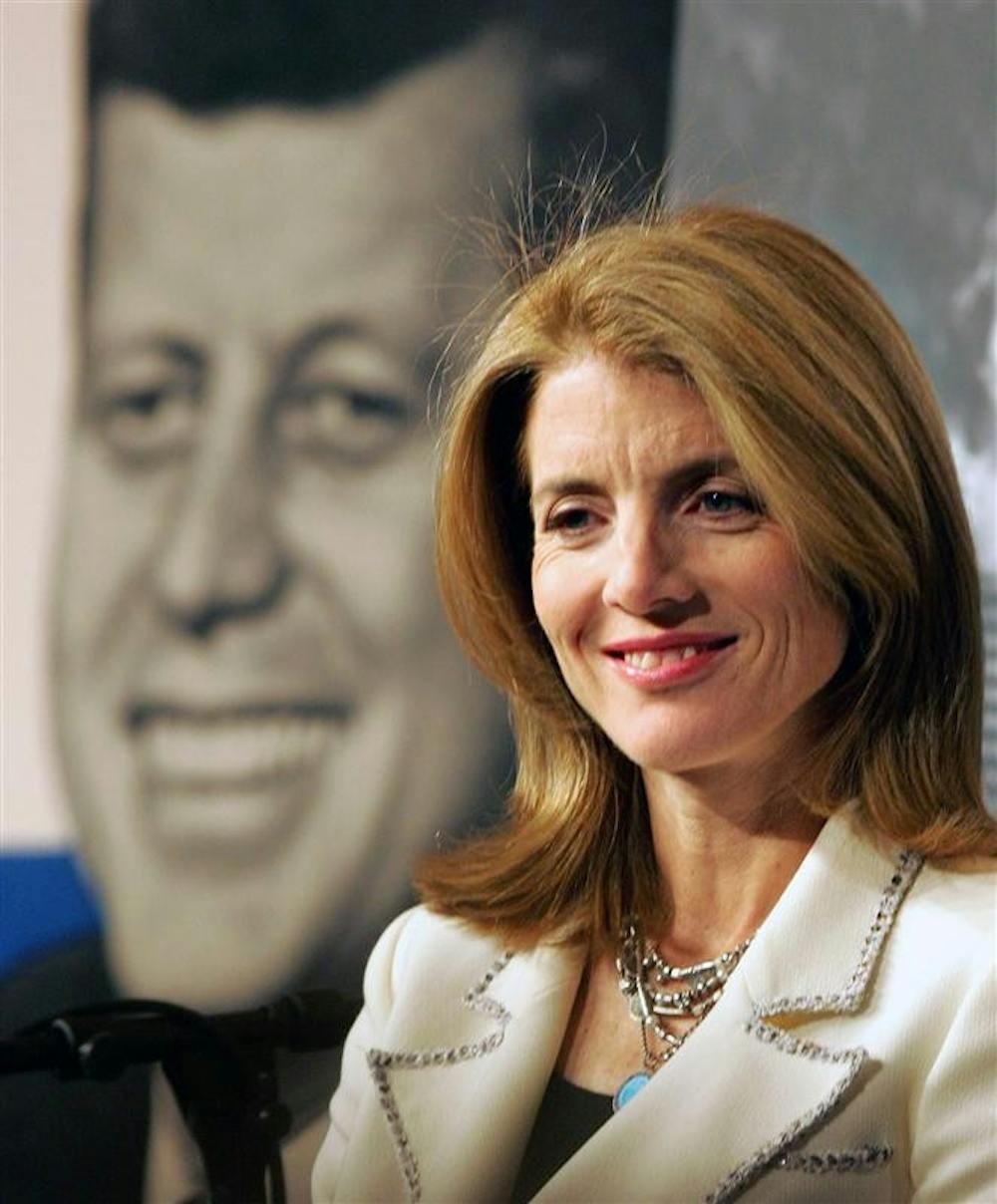 In this March 7, 2005, file photo, Caroline Kennedy, sits in front of an image of her late father President John F. Kennedy at the John F. Kennedy Presidential Library and Museum in Boston. Caroline Kennedy has told New York Gov. David Paterson she wants to be the state's next U.S. Senator, becoming the highest-profile name to actively lobby for the seat being vacated by Hillary Rodham Clinton. 
