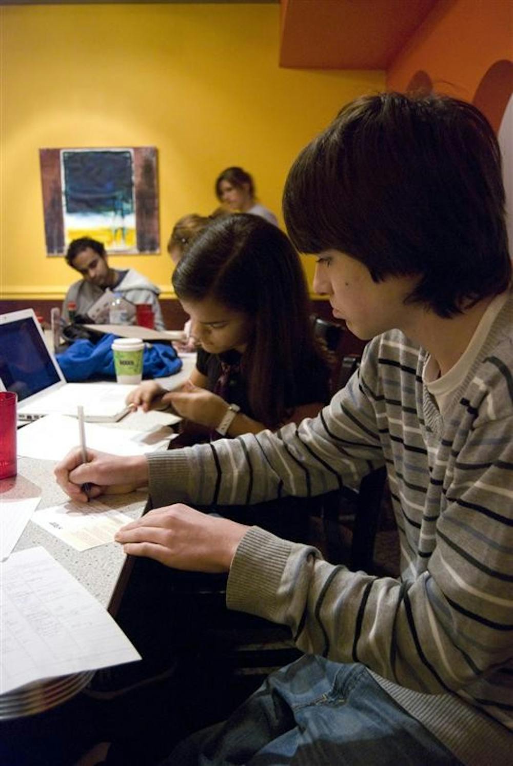 Bloomington High School South freshmen Maggie Christ and Colin Diersing sign postcards to send to Congress at a Young Democrats of Monroe County meeting Monday evening at the Village Deli. The Young Democrats talked about future fundraising, writing letters to Congressmen, and starting high school and college groups.