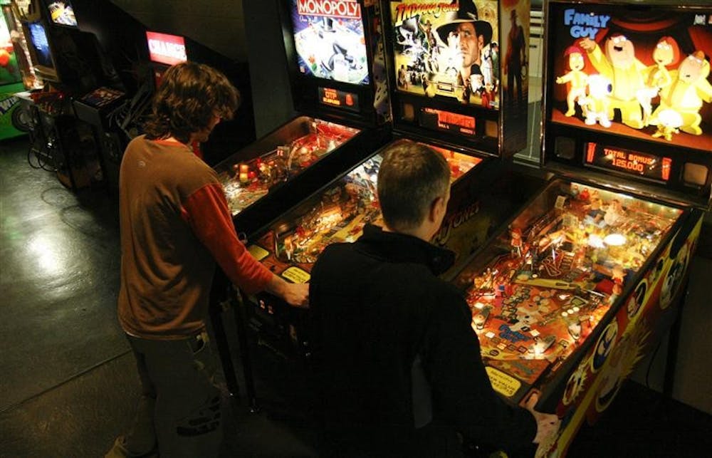 Indiana University students Daniel Miller and Paul Payne play pinball Monday at the Indiana Memorial Union's Back Alley video arcade. Though students might have jobs and be full-time students, there are many regular pinball players, including Daniel, in the Back Alley.