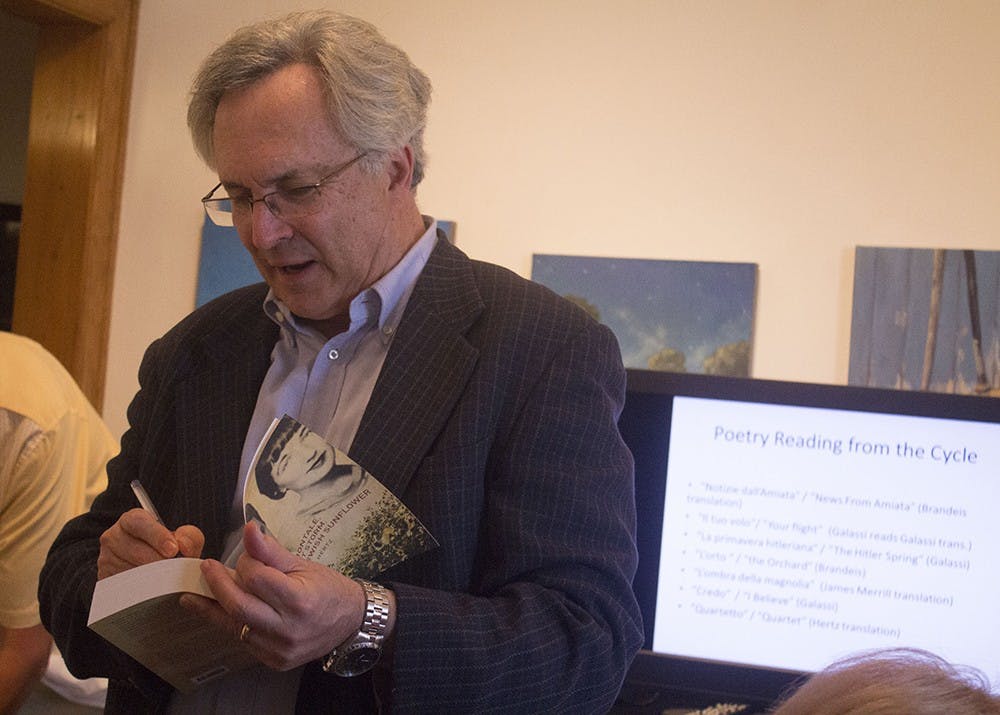 Professor David Hertz signs one of his books for a patron after his lecture on Italian poet Eugenio Montale on Tuesday at the Venue Fine Art and Gifts.