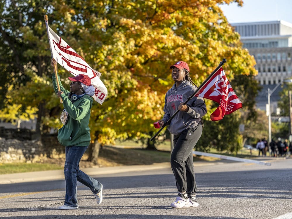 Representatives of the Hoosier Scholars program wave Indiana flags Oct. 7, 2022, in the IU Homecoming Parade on Fee Lane. Both student and community groups were able to walk in the parade.