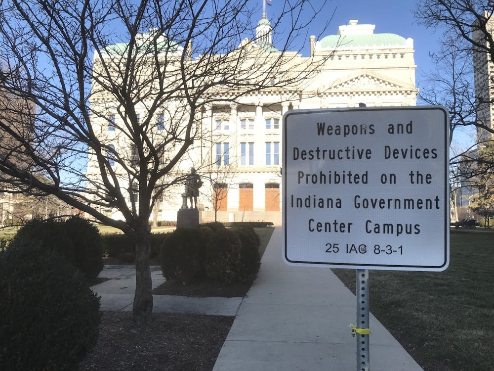 <p>A sign outside the Indiana Statehouse warns against any weapons or firearms on government property Wednesday. No protesters were present for the inauguration of Joe Biden as president. </p>