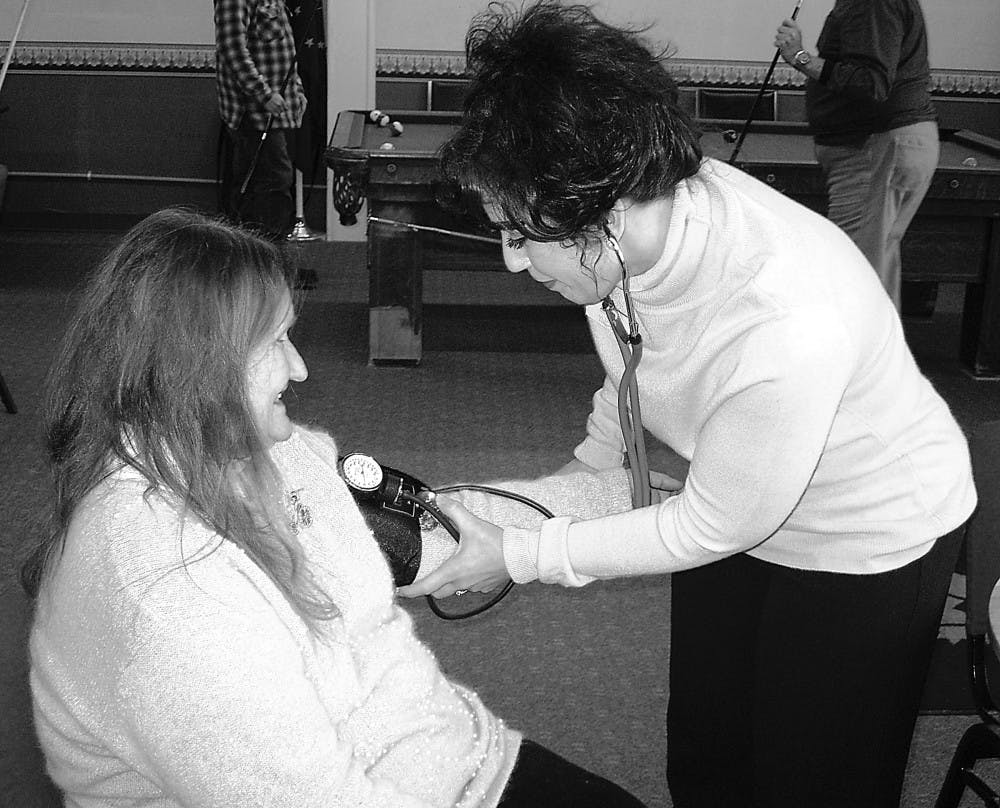 Lori Brenner, RN, checks a patient’s blood pressure at the Bloomington Adult Community Center.