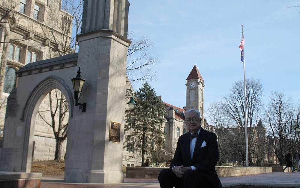 Edson Sample sits in front of the Sample Gates. Sample funded the construction of the gates and dedicated them to his parents.