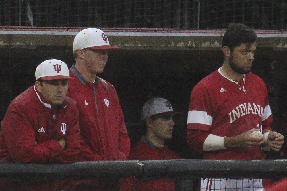 Tony Butler, Scotty Bradley and Austin Cangelosi watch the last few innings of play against Louisville as the rain pours down at Jim Patterson stadium on Wednesday night. IU lost 9-2 in their last mid-week game of the season.