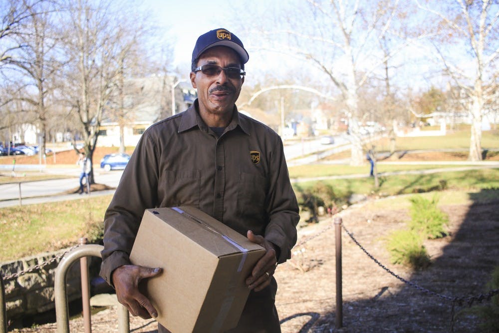 <p>Orlando Driver, United Parcel Service delivery driver, stands with a box outside Franklin Hall on Dec. 2. Driver has been working with UPS for 36 years, and he is referred to as the "king of Kirkwood."</p>