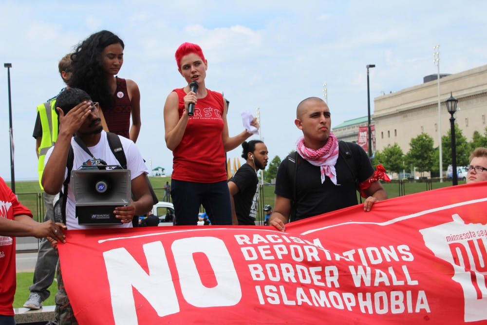 Kait McIntyre, 27, speaks to the crowd at the end of the march at the Veterans Memorial Square. She tells participants they must all work together to end racism and defeat Trump.