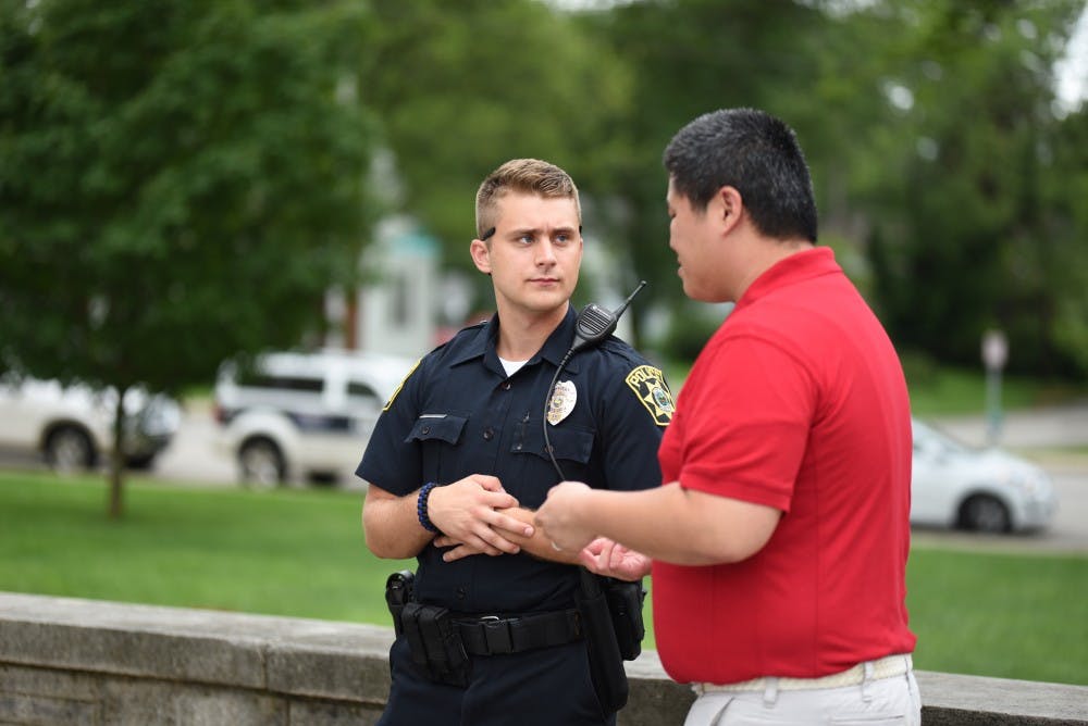 Weslee Radzikowski from the IUPD talks to Forest residence manager Paul Hafner outside of Forest residence hall on Wednesday morning. 