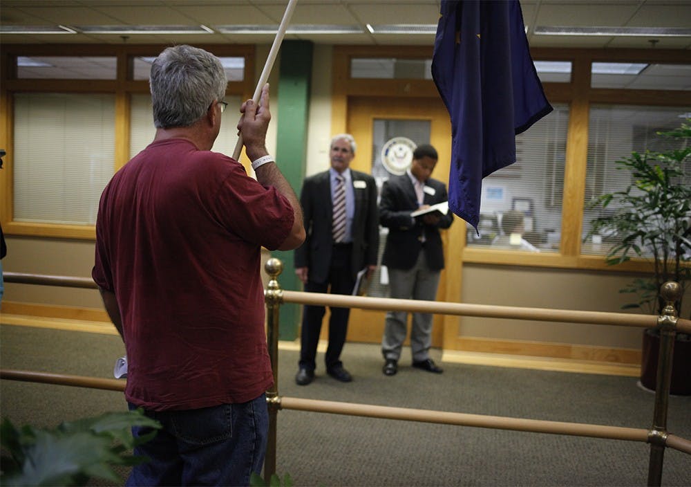 Hal Turner, Bloomington district office manager for Congressman Todd Young, listens as protester Randy Brown holds the Indiana state flag and makes a statement regarding The Affordable Care Act Wednesday in Showers Plaza.  The protest was held to bring attention to Congressional exemption of the act.  