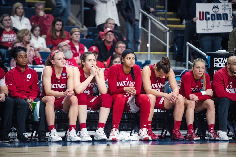 <p>From left to right, Grace Berger, Mackenzie Holmes, Kiandra Browne, Ali Patberg, and Nicole Cardaño-Hillary sit on the bench as the final seconds run off the clock Mar. 26, 2022, at Total Mortgage Arena in Bridgeport, Conn. Indiana lost 75-58 against the University of Connecticut.</p>
