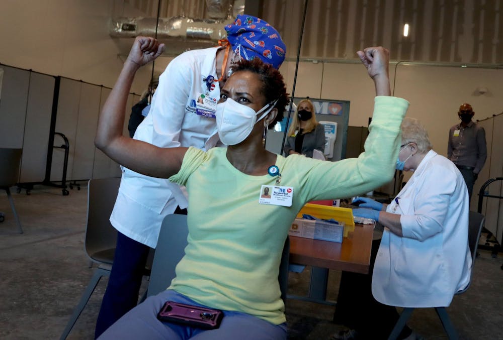 <p>Ayanna Phillips, a Memorial Health systems analyst, celebrates after receiving the COVID-19 vaccine Monday in Miramar, Florida.</p>