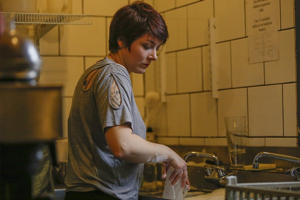Employee Hannah Osbourne washes the dishes Wednesday at Runcible Spoon. 