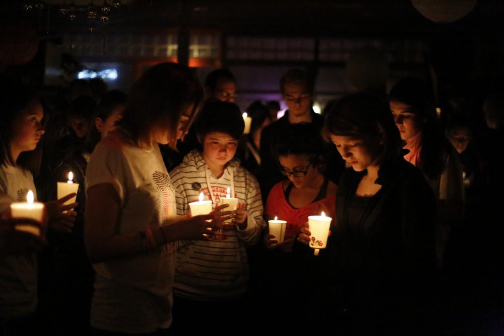 Members of the Prism Youth Community share a moment of silence by candlelight thrusday during the vigil held in memory of transgender teen, Leelah Alcorn, at Rachel's Cafe