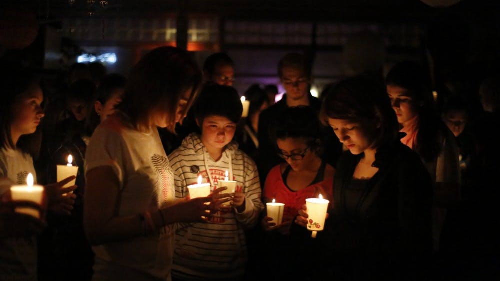Members of the Prism Youth Community share a moment of silence by candlelight thrusday during the vigil held in memory of transgender teen, Leelah Alcorn, at Rachel's Cafe