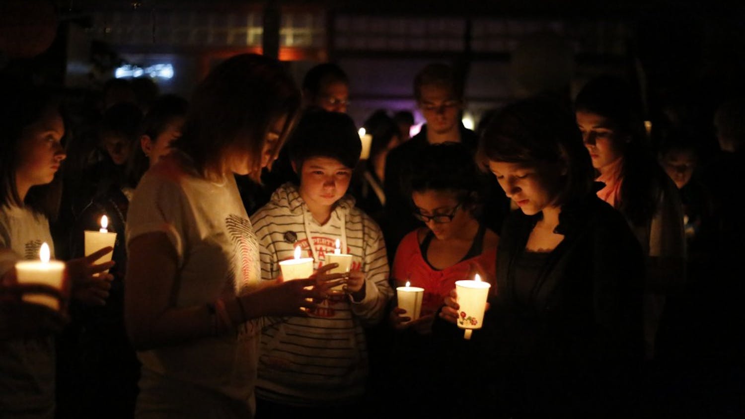 Members of the Prism Youth Community share a moment of silence by candlelight thrusday during the vigil held in memory of transgender teen, Leelah Alcorn, at Rachel's Cafe