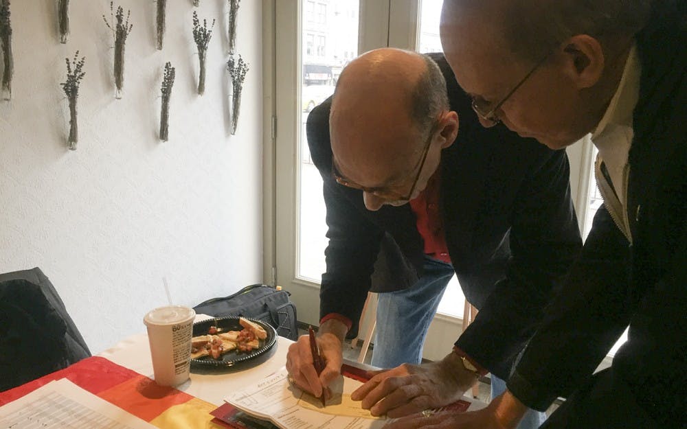 William Yarber signs a check to put the GLBT Alumni Association's scholarship fund to more than&nbsp;$1 million. Mike Shumate&nbsp;recently received the GLBTAA Distinguished Alumni Award and&nbsp;helped kickstart the scholarship fund.