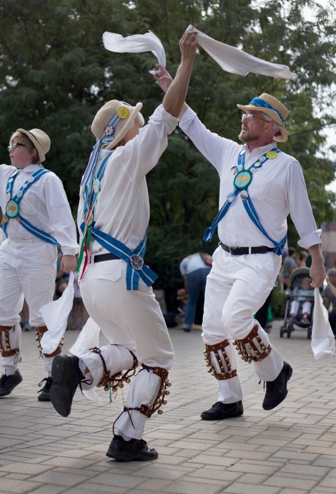 Martha Marmouze and Jeremy Nottinham perform Saturday at the Farmers Market in downtown Bloomington with their traditional English dance group, the Bloomington Quarry Morris. The group was founded more than 30 years ago and includes members from a variety of ages. 