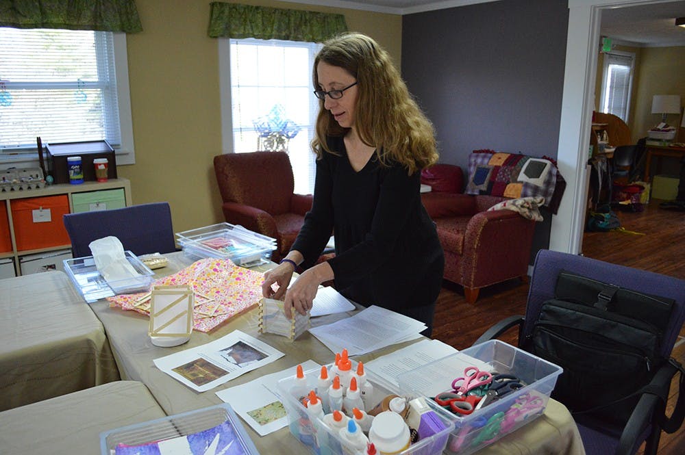 Art therapist Paula Worley assembles a popsicle stick lantern as a demonstration for the art therapy session Thursday morning at the Better Day Club. The club is an adult day center for individuals suffering from cognitive changes due to aging, Alzheimer's or other forms of dementia.