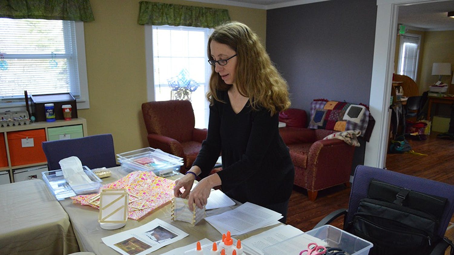Art therapist Paula Worley assembles a popsicle stick lantern as a demonstration for the art therapy session Thursday morning at the Better Day Club. The club is an adult day center for individuals suffering from cognitive changes due to aging, Alzheimer's or other forms of dementia.