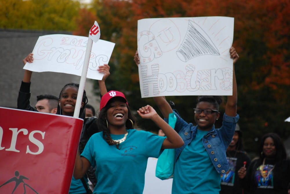 <p>Members of the Groups Scholars Program cheer as they march along Kirkwood Avenue at the Homecoming Parade on Oct. 16, 2015.</p>