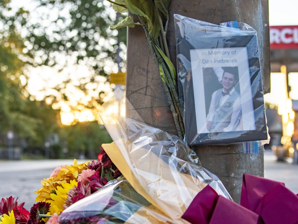 The sun sets Oct. 1 behind a memorial to Daniel Plebanek at the corner of Third Street and Indiana Avenue. Dr. Plebanek was given a posthumous Ph.D. after he was killed in an accident last week.